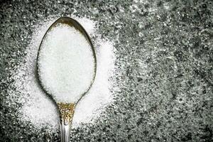 Sugar in a teaspoon. photo