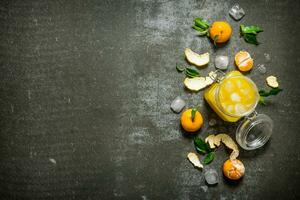 Fresh juice with mandarins, leaves, and ice. photo