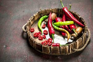 Hot pepper in a wooden tray with knife. photo