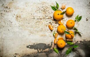 Fresh mandarins with leaves. On rustic background. photo