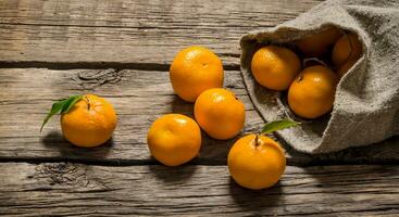 Fresh tangerines in an old bag of leaves. photo