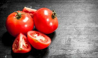 Fresh tomatoes . On black chalkboard. photo