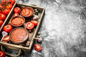 Tomato sauce with herbs, spices and garlic on wooden tray. photo