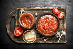 Tomato sauce with garlic and hot peppers on the Board. photo