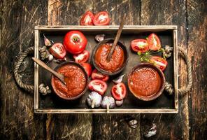 Tomato sauce with spices and garlic in the old tray. photo