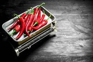 Fresh hot chili pepper on scales. photo