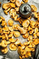 Fresh chanterelles mushrooms with herbs and an old knife on a steel tray. photo