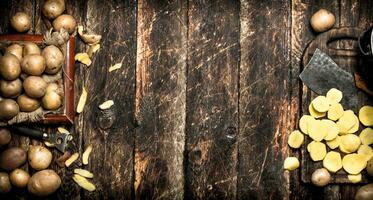 el rebanado patatas en un antiguo de madera tablero. en de madera antecedentes. foto