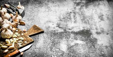 Spicy garlic press tool. On rustic background. photo