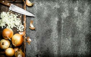 Fresh chopped onion on the old Board. On rustic background. photo