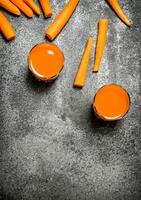 Fresh carrot juice. On rustic background. photo