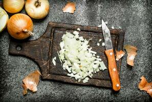 Fresh chopped onion on the old Board. On rustic background. photo