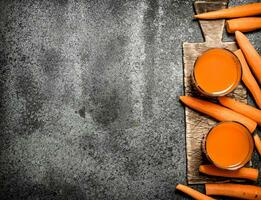 Fresh carrot juice. On rustic background. photo