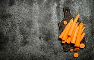 Fresh carrots on the old Board. On rustic background. photo