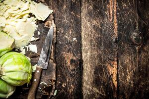 Shredded fresh cabbage on the Board. On the old wooden table. photo