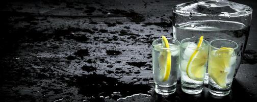 Vodka in glasses with lemon and ice. photo