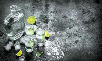 Vodka with pieces of lime and ice cubes. photo