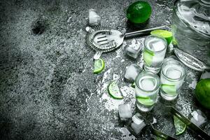 Vodka with pieces of lime and ice cubes. photo