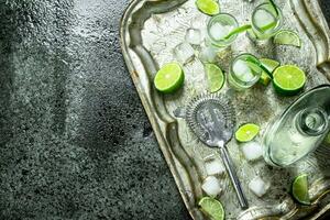 Vodka with lime and ice on a steel tray. photo
