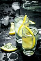 Vodka in glasses with lemon and ice. photo