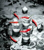Vodka shots with hot chili peppers and ice. photo