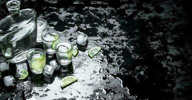 Vodka shots with lime and ice. photo