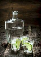 Vodka shots with ice and fresh lime. photo