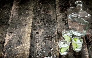 Vodka shots with ice and fresh lime. photo