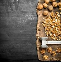 Crushed walnuts with a hammer on the old Board. photo