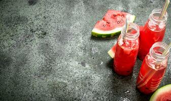 Watermelon juice in bottles with straws. photo