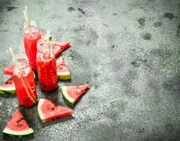 Watermelon juice in bottles with straws. photo