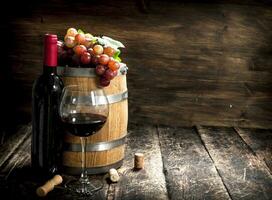 barrel of red wine with grapes and a corkscrew. photo