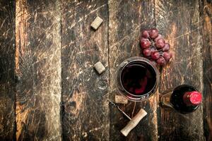 bottle of red wine with a corkscrew. photo