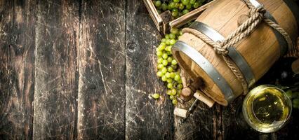 vino antecedentes. un barril de blanco vino con ramas de verde uvas. foto