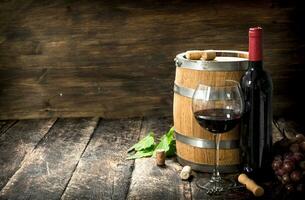 barrel of red wine with grapes and a corkscrew. photo