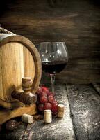 Wine background. A barrel with red wine and freshly grapes. photo