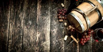 Wine background. A barrel with red wine and freshly grapes. photo