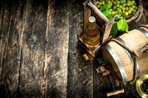 Wine background. A barrel of white wine with branches of green grapes. photo