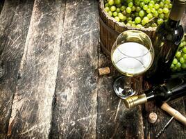 White wine with a bucket of green grapes. photo