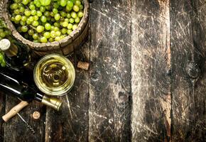 White wine with a bucket of green grapes. photo