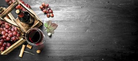 Red wine with fresh grapes in a box. photo