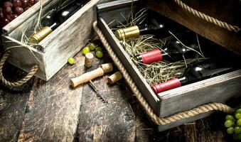 Wine background. Bottles of red and white wine in old boxes. photo