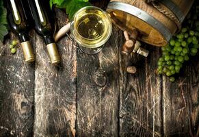 Wine background. A barrel of white wine with branches of green grapes. photo