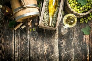 Wine background. White wine with a bucket of green grapes. photo