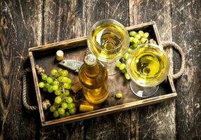 blanco vino con Fresco uvas en un antiguo bandeja. foto