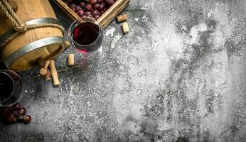 Wine background. A barrel with red wine and fresh grapes. photo