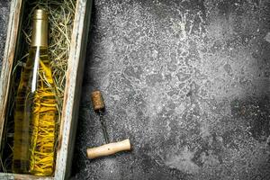 vino antecedentes. un botella de blanco vino en un antiguo caja. foto