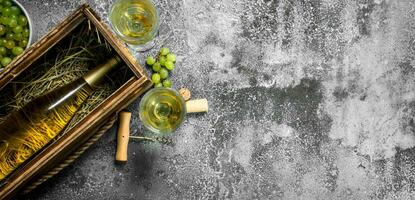 Wine background. A bottle of white wine in an old box. photo