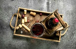 Red wine on a wooden tray. photo