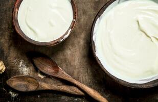 Natural yogurt in a bowl with a spoon. photo